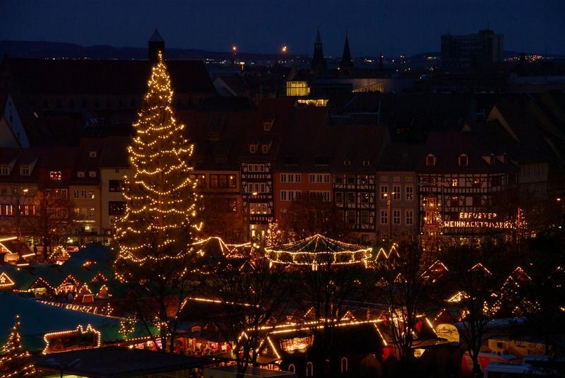 Weihnachtsmarkt mit großem Tannenbaum am Abend